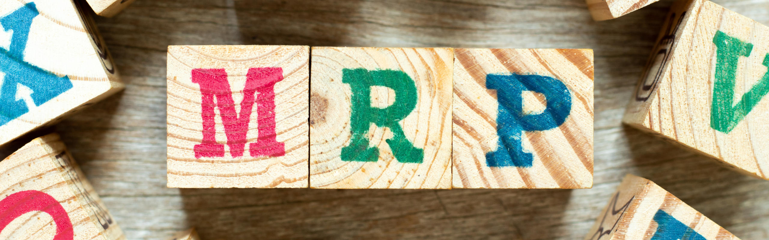 Alphabet letter block in word MRP (Abbreviation of Material requirements planning) with another on wood background