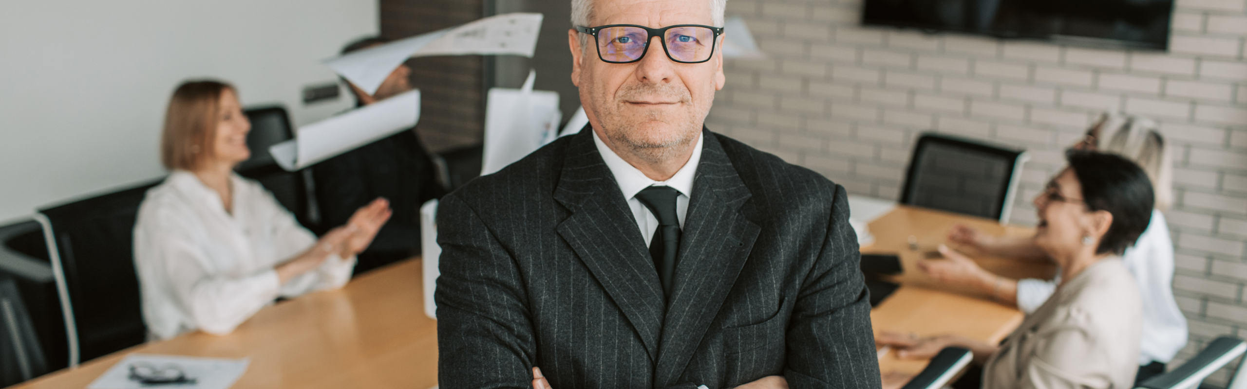 Man in Black Suit Standing with His Arms Crossed
