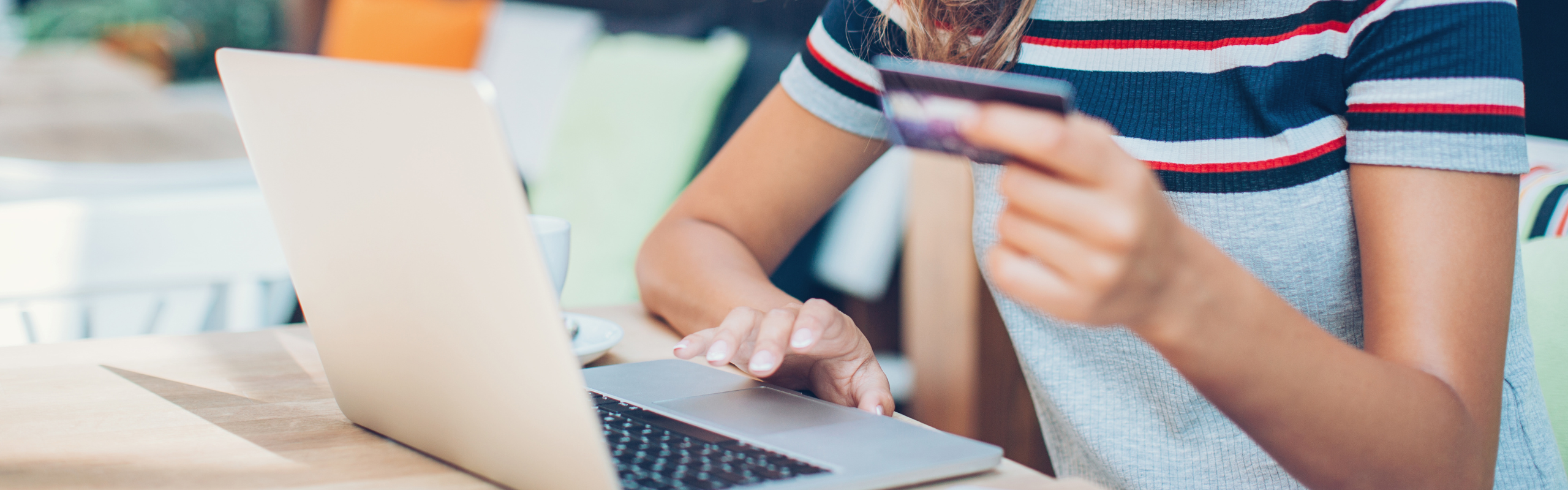 Woman using her laptop and holding credit card