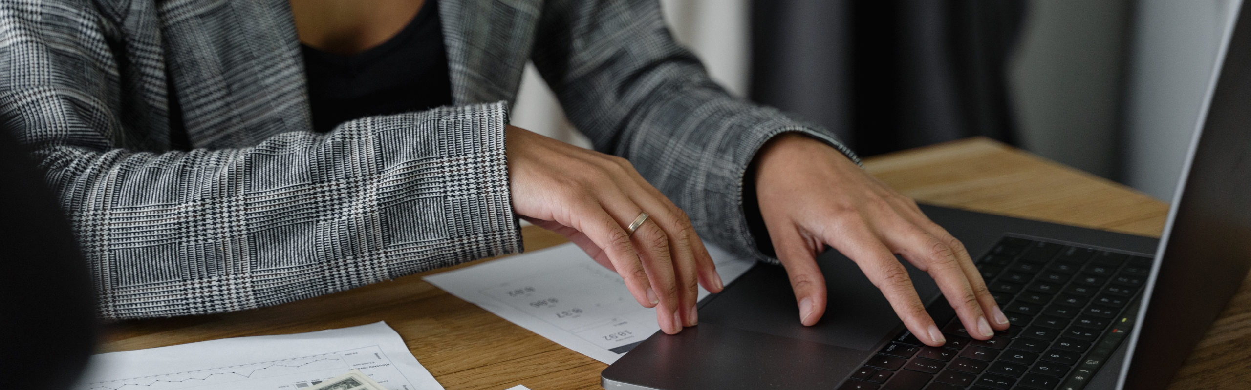 A Woman in Plaid Blazer Using Her Laptop
