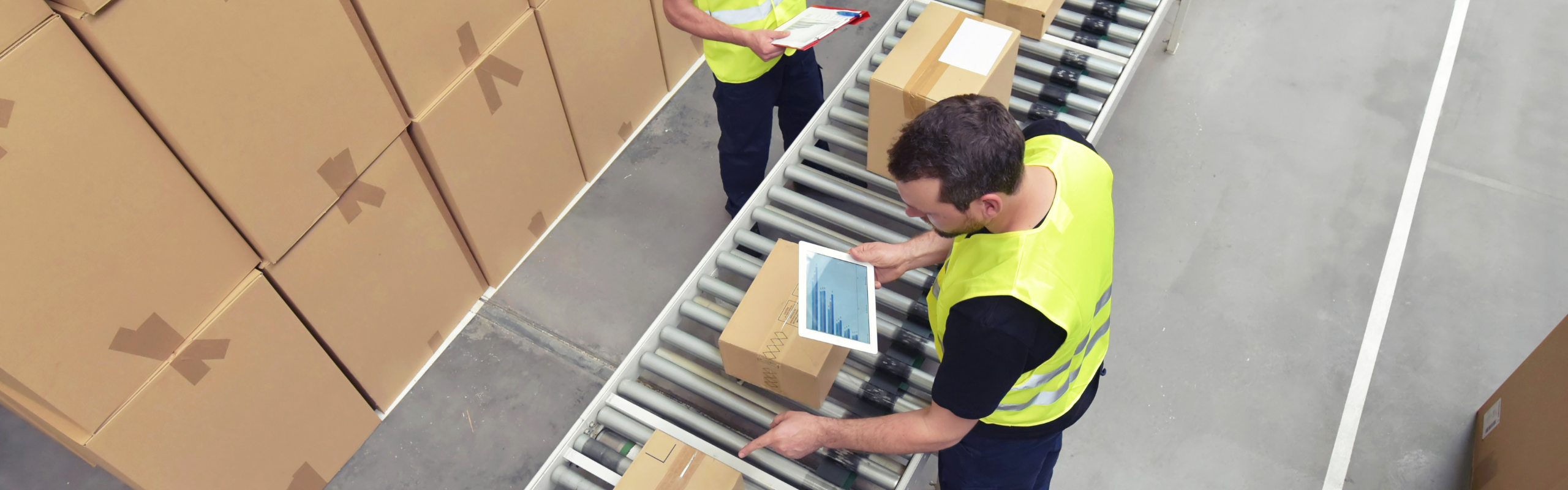 Worker in a warehouse in the logistics sector processing packages on the assembly line - transport and processing of orders in trade