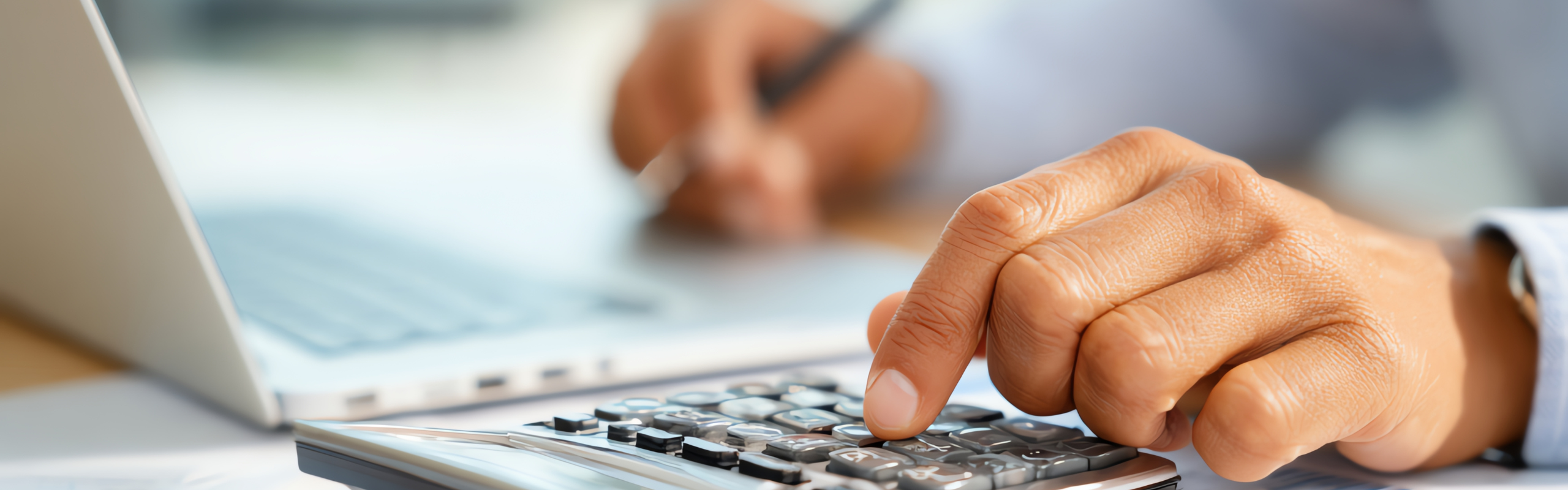 Accountant calculating company expenses with calculator and laptop