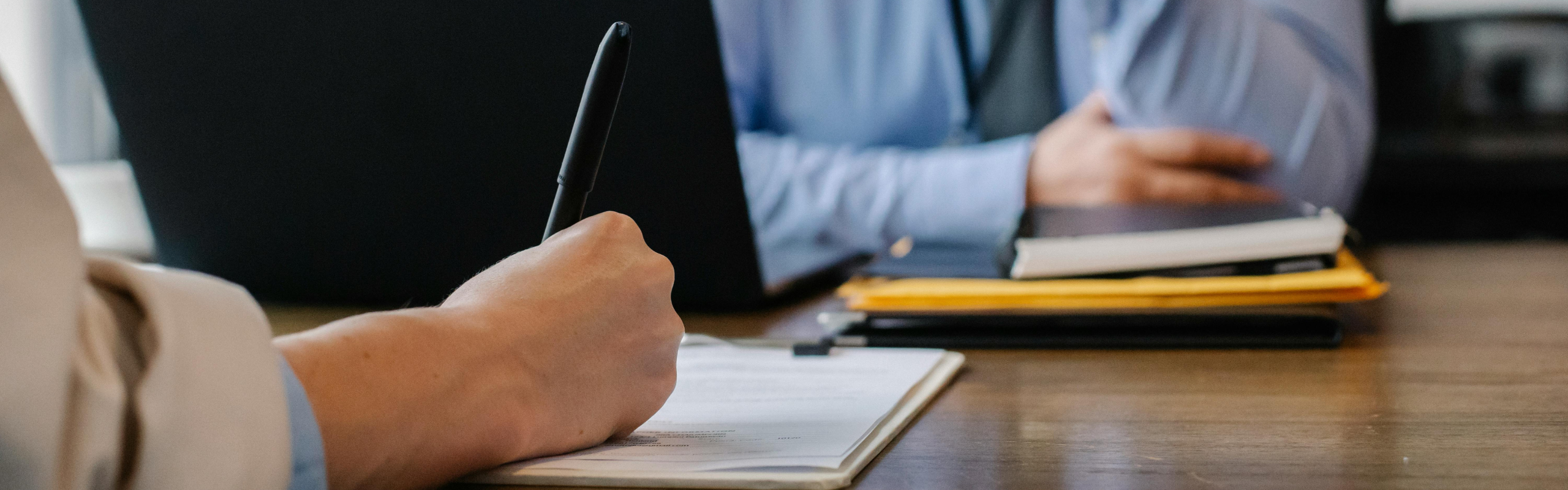 Woman filling job application form in office with boss