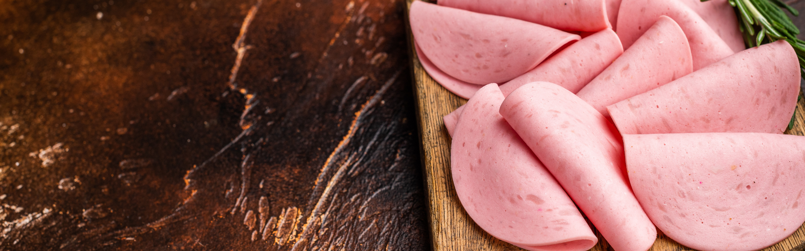 Heap of processed luncheon meat slices (salami) on a wooden boar