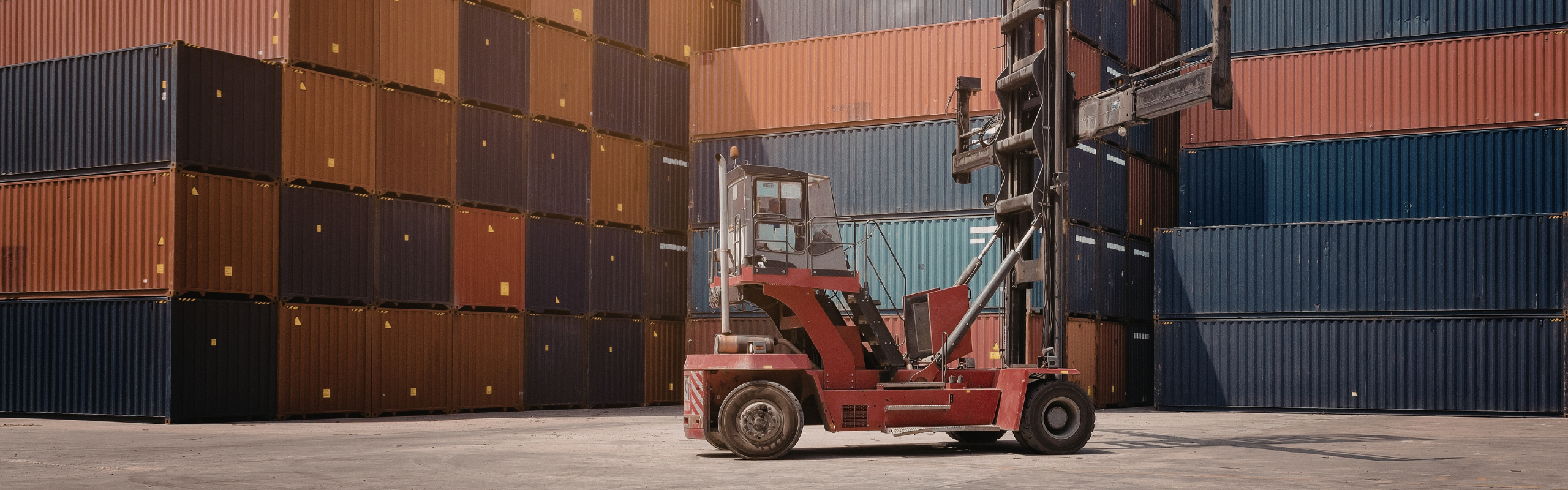 Container terminal with forklift at work during sunset